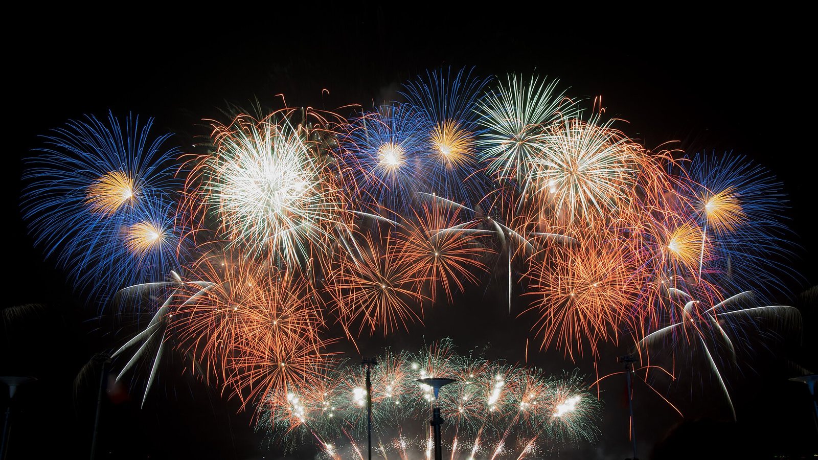 Feux d'artifice dorés éclairant un ciel de nuit bleu profond